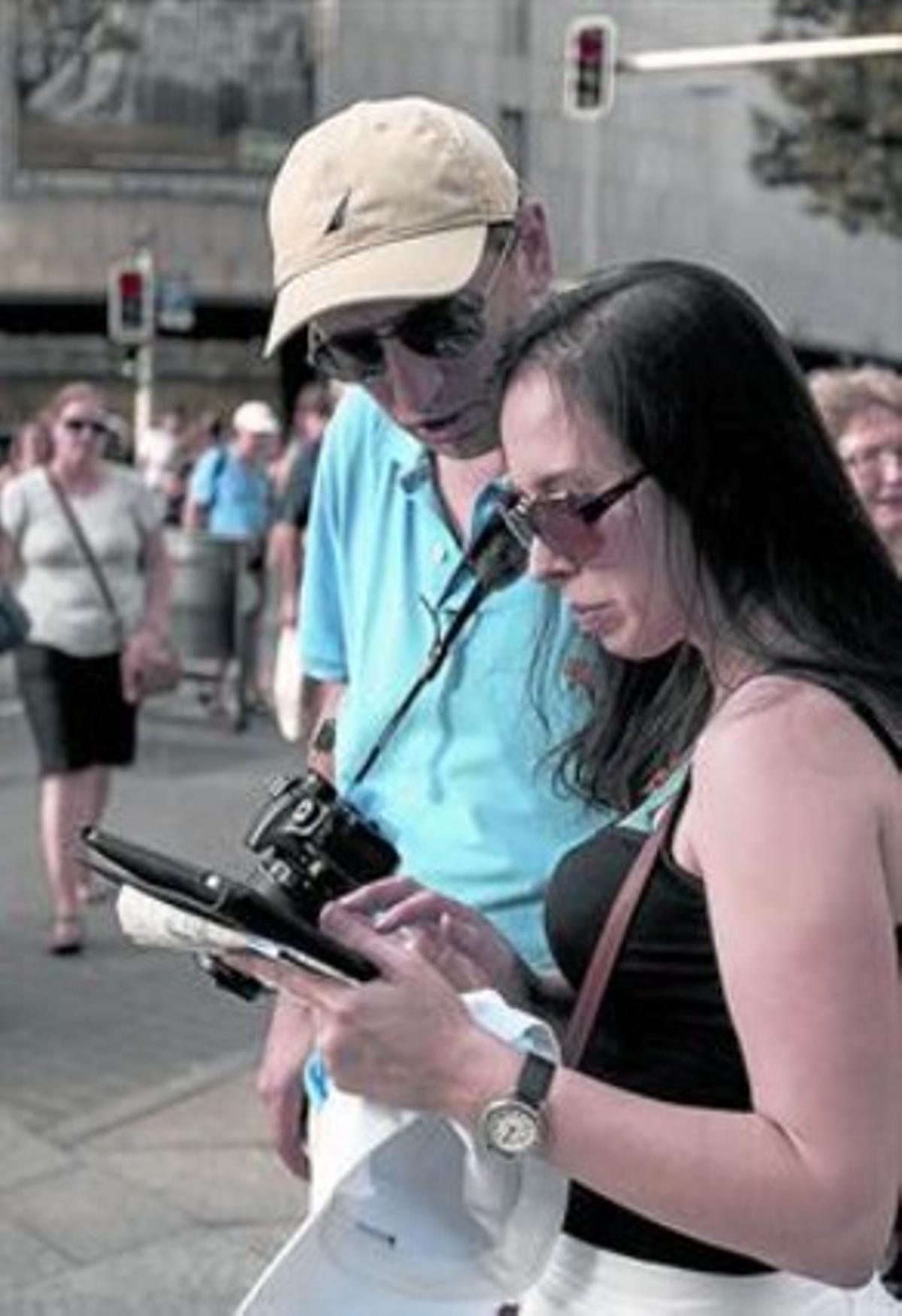 Turistas acceden a internet desde una tableta en Barcelona.