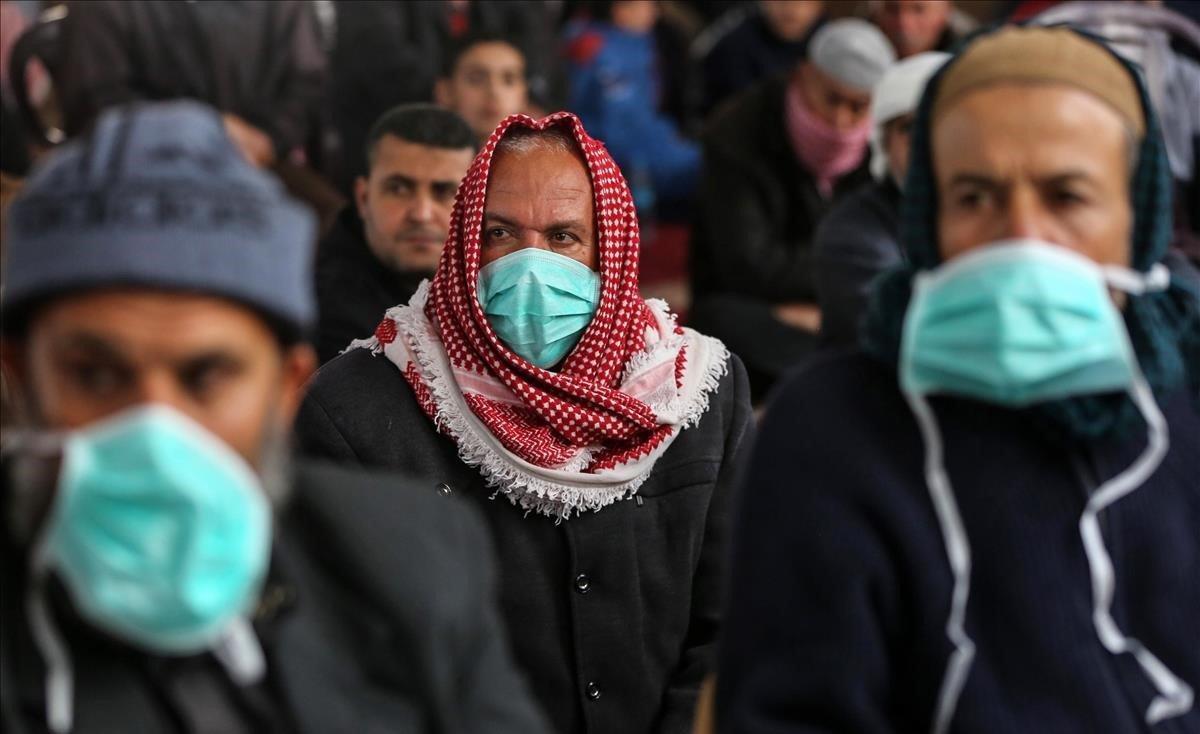 Musulmanes palestinos se protegen con máscaras durante el sermón del viernes, en Khan Youinis, Gaza. 