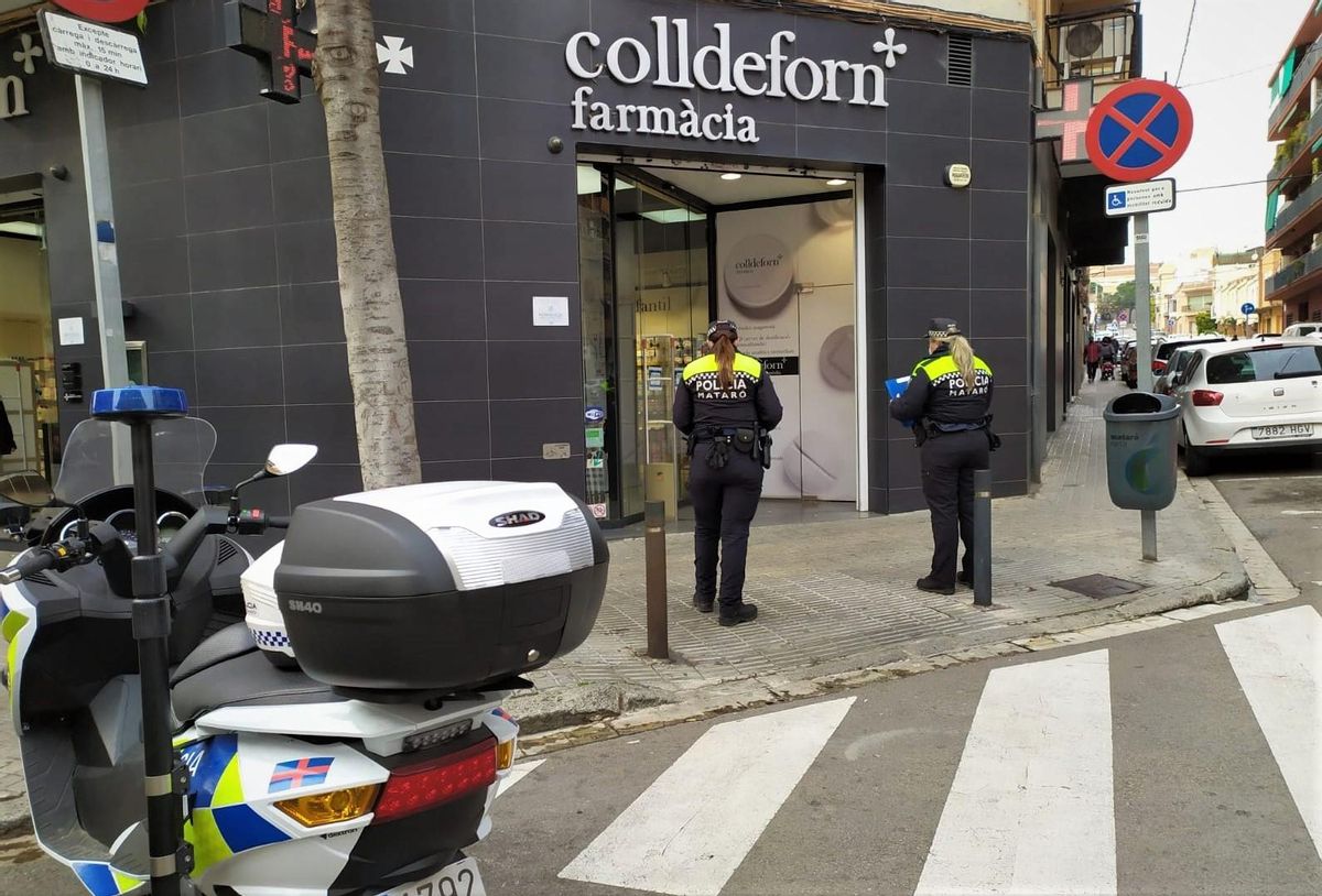 Dos agentes de la Policía Local de Mataró frente a una farmacia de la ciudad. Dos agentes de la Policía Local de Mataró frente a una farmacia de la ciudad.