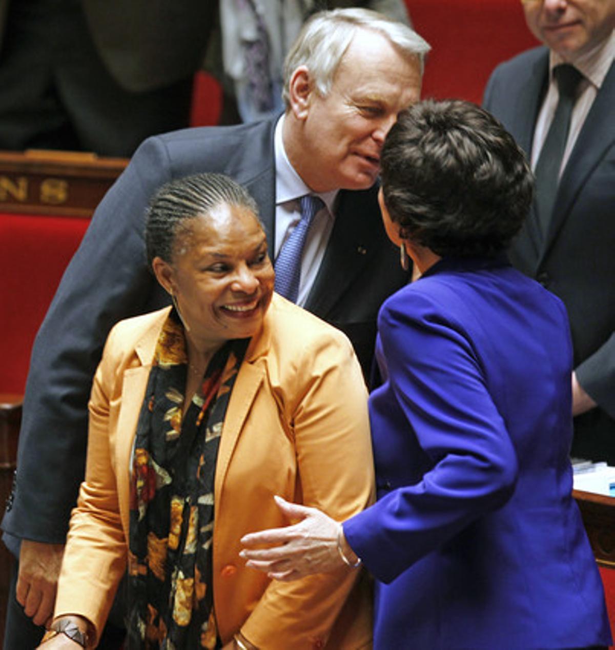 El primer ministro francés, Jean-Marc Ayrault, felicita a la titular de Familia, Dominique Bertinotti (derecha), en presencia de la ministra de Justicia, Chistiane Taubira, este martes.