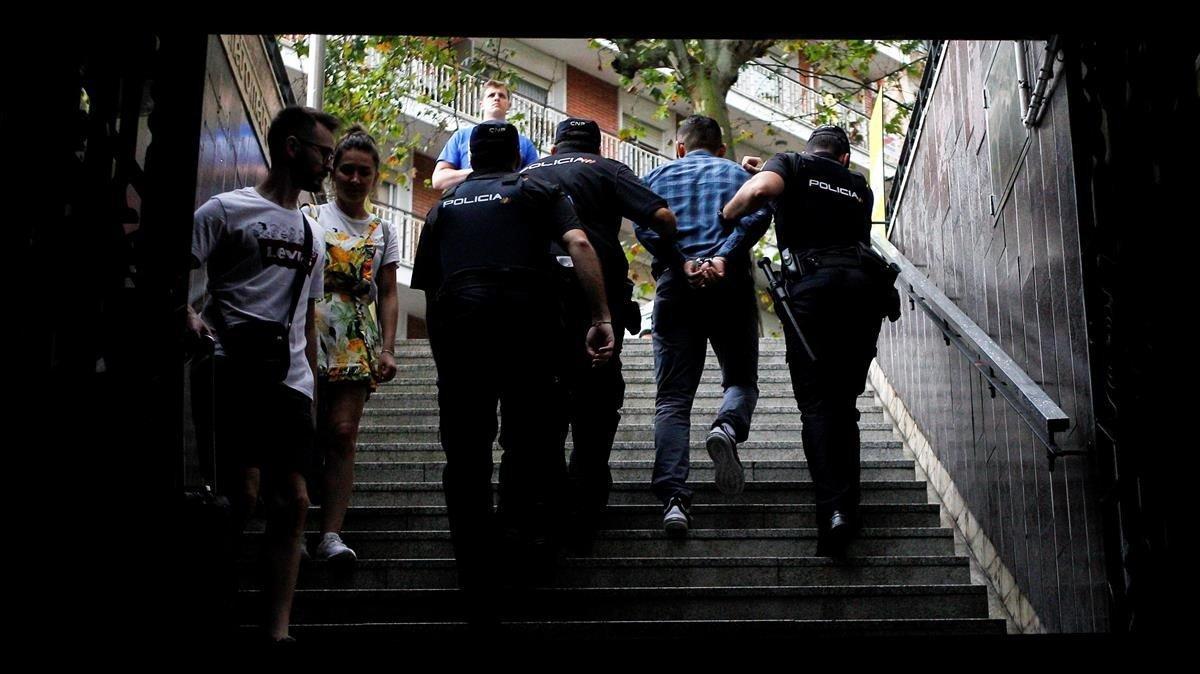 Dos policías se llevan a un detenido en el metro de Barcelona, en agosto pasado.