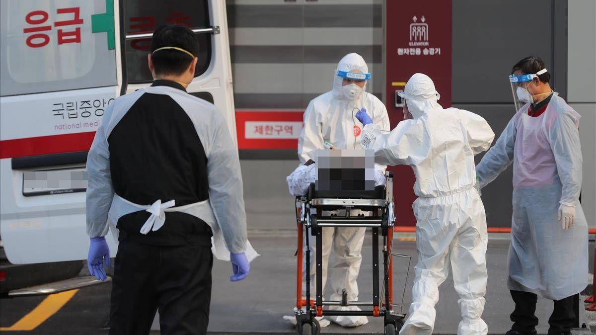 Médicos llevan a un infectado del covid-19 al hospital en Seúl, Corea de Sur