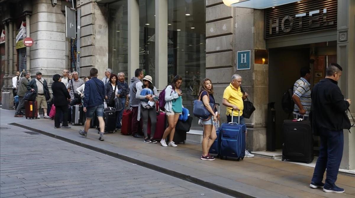 Turistas en la calle Ferran, haciendo cola para entrar al Hotel Rialto. Turistas en la calle Ferran, haciendo cola para entrar al Hotel Rialto.