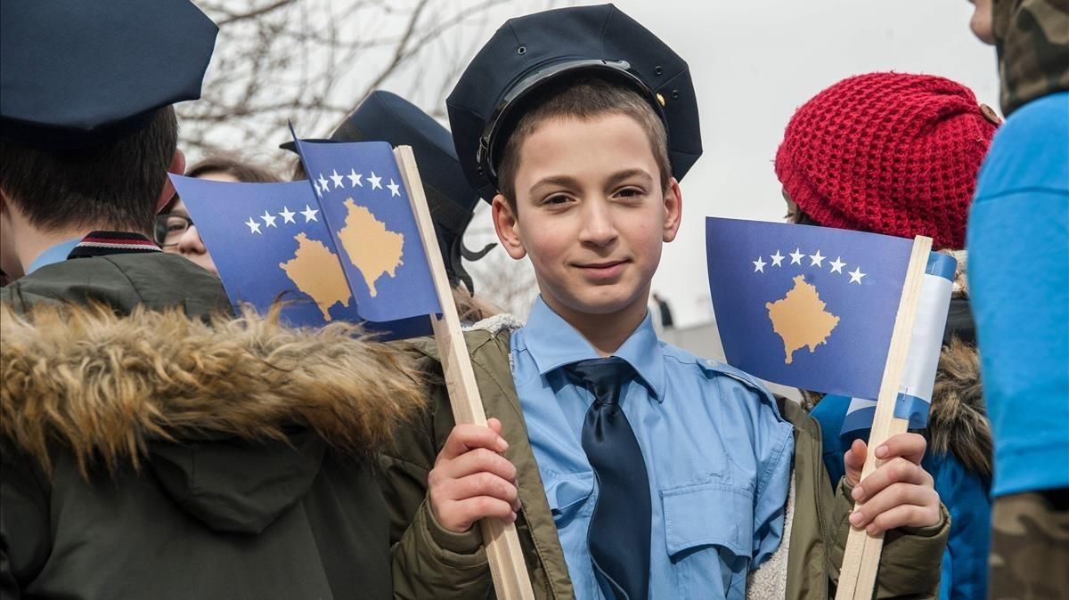 Un niño vestido de policía sostiene la bandera kosovar. este viernes, para celebrar los 10 años de independencia. Un niño vestido de policía sostiene la bandera kosovar. este viernes, para celebrar los 10 años de independencia.
