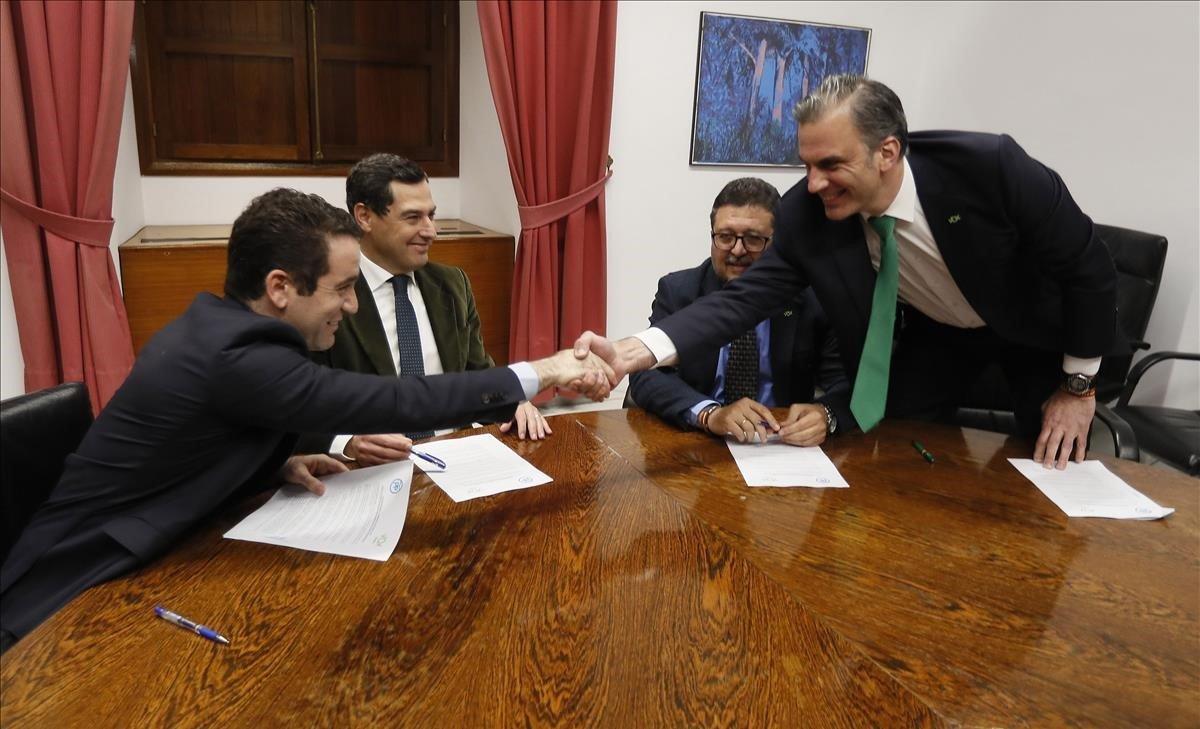 Los secretarios generales del PP, Teodoro García Egea, y de Vox, Francisco Javier Ortega Smith, estrechan las manos delante de los líderes andaluces del PP, Juanma Moreno y de Vox, Francisco Serrano, durante una reunión esta tarde en el Parlamento de Andalucía.