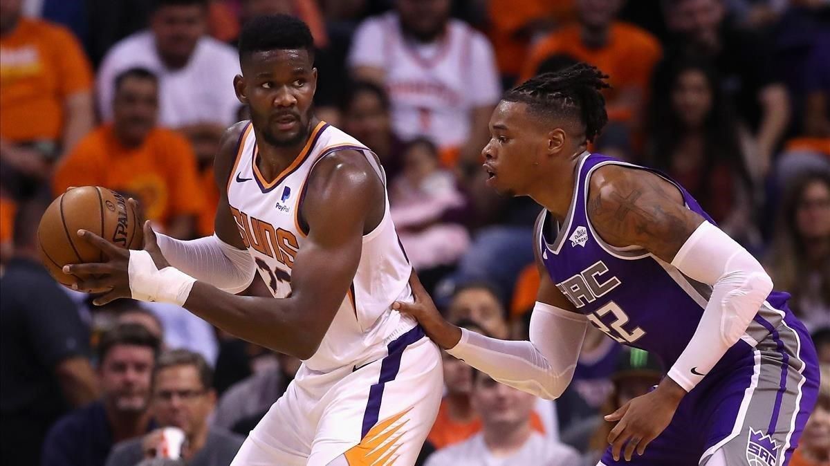 DeAndre Ayton, a la izquierda, defendido por Holmes. DeAndre Ayton, a la izquierda, defendido por Holmes.