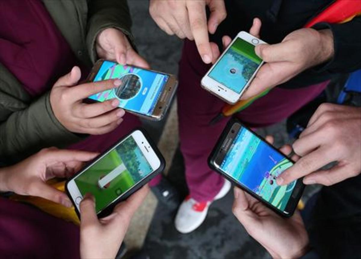 Cuatro adolescentes juegan en grupo a Pokémon Go en Sídney (Australia).