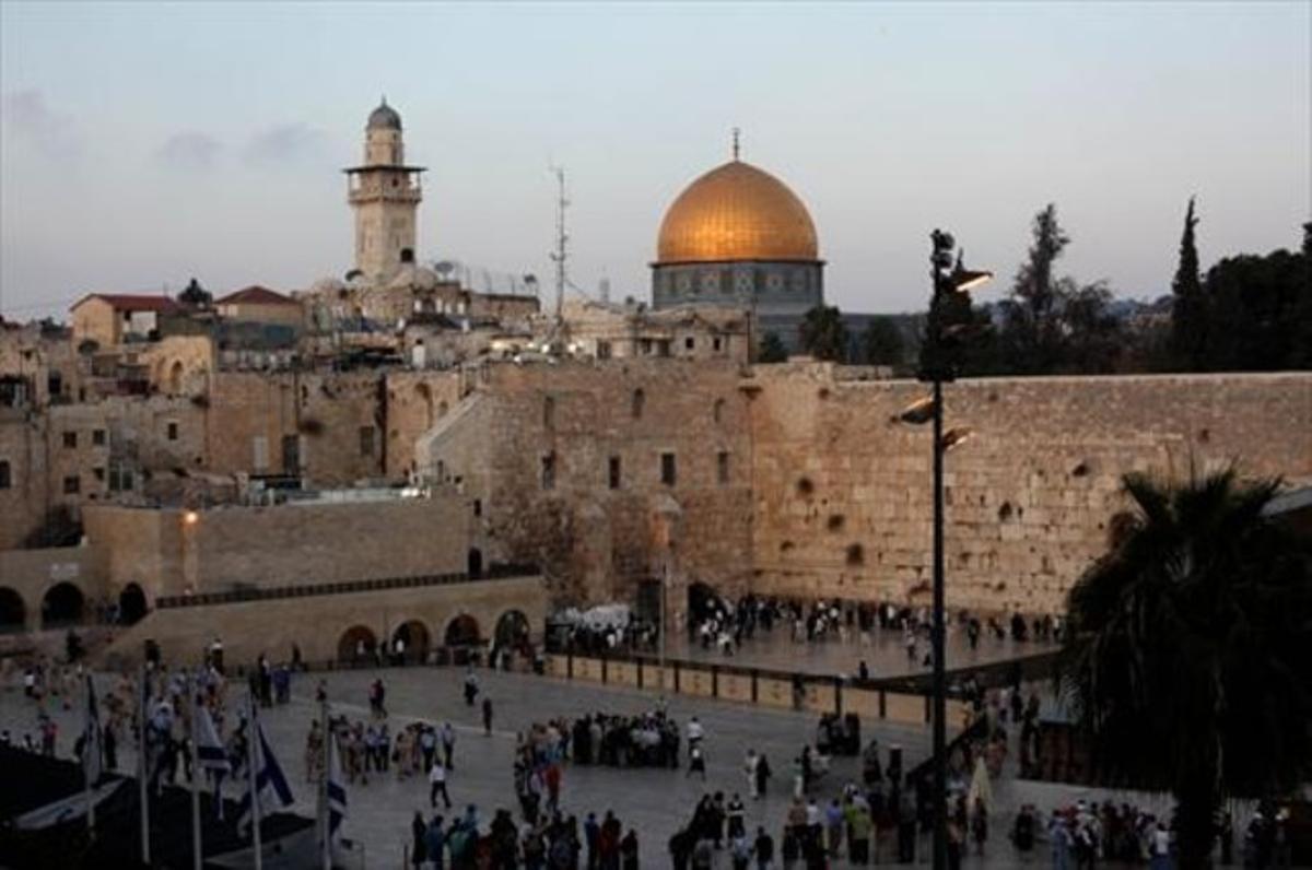 El Muro de las Lamentaciones, en primer plano, con la mezquita de la Cúpula de la Roca en el fondo, en la Ciudad Vieja de Jerusalén.
