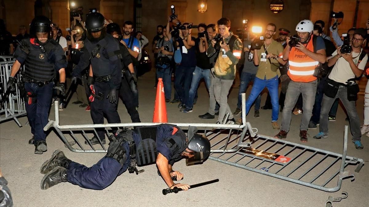 Un mosso acaba en el suelo tras tirarle una valla, en el Parlament. Un mosso acaba en el suelo tras tirarle una valla, en el Parlament.