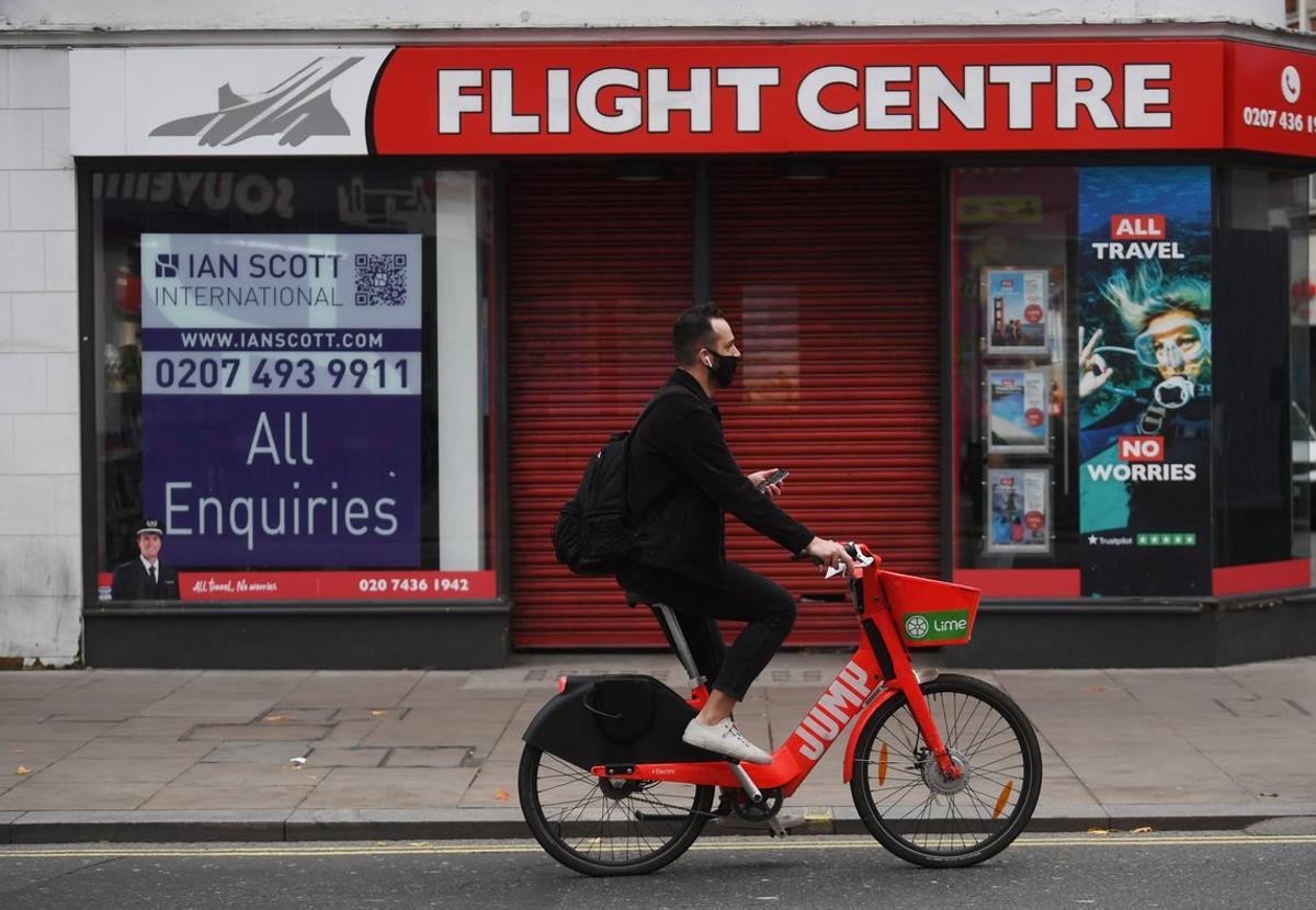 Un ciclista pasa por delante de una agencia de viajes en Londres.