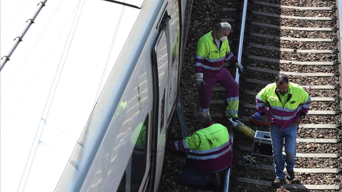 Varios operarios trabajan en el tren Alvia que descarriló en las cercanías de León, este lunes. Varios operarios trabajan en el tren Alvia que descarriló en las cercanías de León, este lunes.