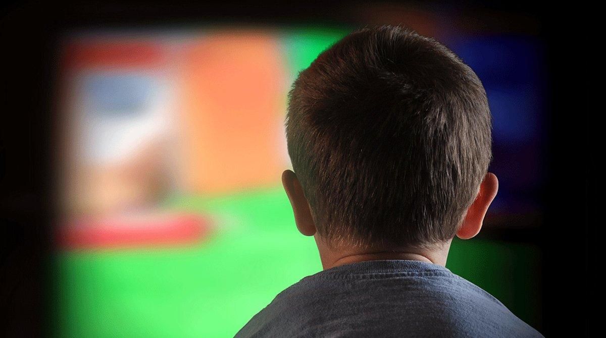 Un niño mira atentamente la televisión. Un niño mira atentamente la televisión.