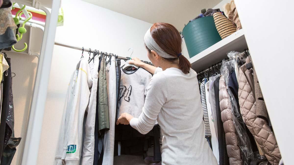 Una mujer ordena ropa en su armario. Una mujer ordena ropa en su armario.