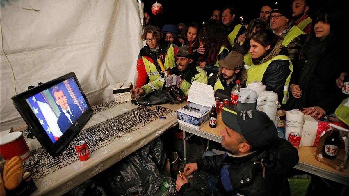 Unos ’chalecos amarillos’ siguen el discurso de Macron por televisión, en La Ciotat, cerca de Marsella. Unos ’chalecos amarillos’ siguen el discurso de Macron por televisión, en La Ciotat, cerca de Marsella.