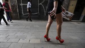 Una mujer camina por el Raval de Barcelona.