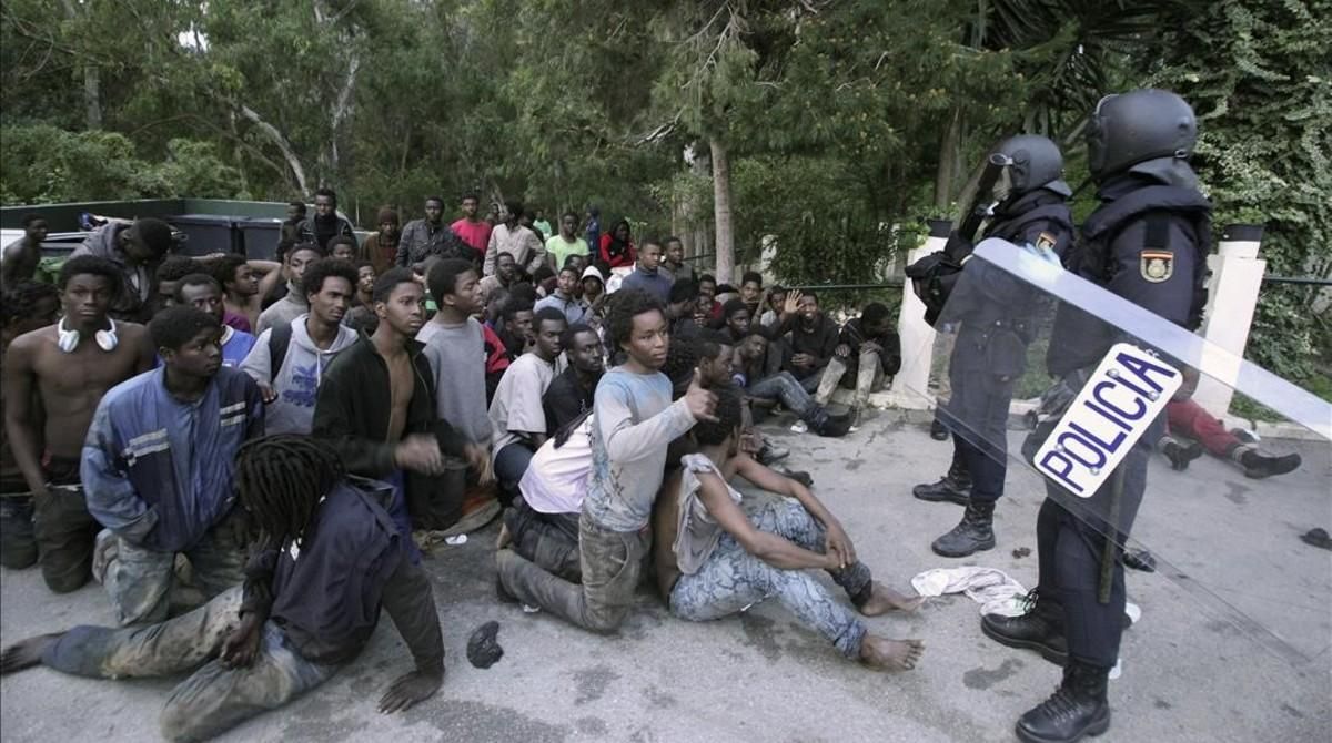 Inmigrantes retenidos tras saltar la valla en Ceuta el pasado febrero. Inmigrantes retenidos tras saltar la valla en Ceuta el pasado febrero.