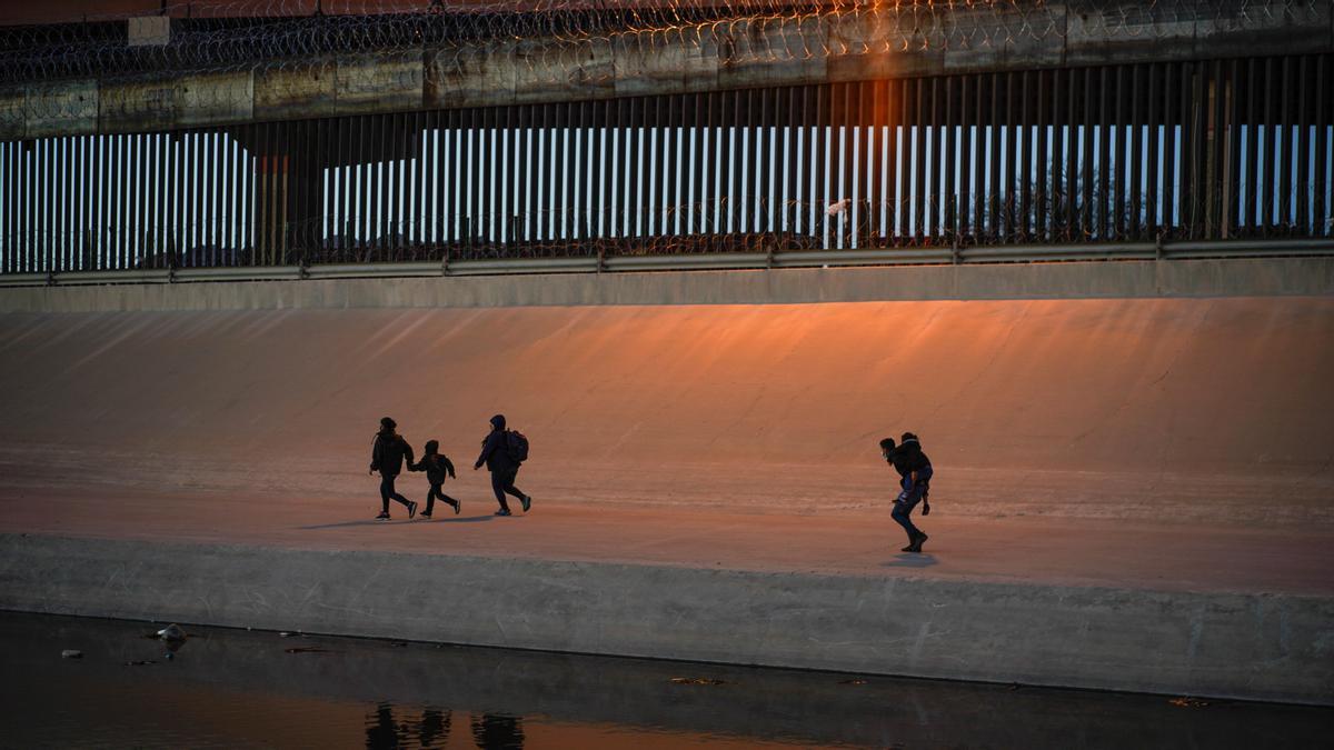 Migrantes cruzando el muro entre México y EEUU en la zona de El Paso