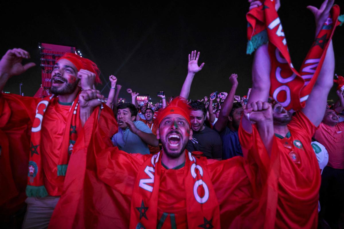Aficionados marroquíes celebran en Doha la clasificación de su equipo a cuartos del Mundial de Qatar tras derrotar a España. 