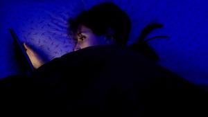 Una adolescente se entretiene con una pantalla antes de dormir, en su casa de Madrid.