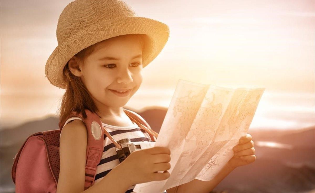 Una niña pequeña observa un mapa. Una niña pequeña observa un mapa.