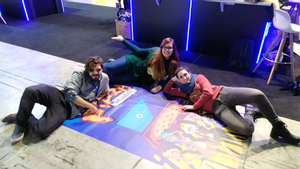 Anna Guxens (derecha) y su equipo, tumbados sobre una imagen promocional del videojuego ’The Pizza Situation’.