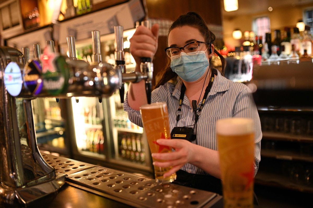 Una empleada de un pub de Manchester sirve una cerveza de barril. Una empleada de un pub de Manchester sirve una cerveza de barril.