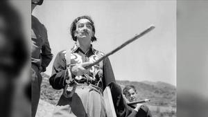 Dalí con uno de sus bastones y el niño Joan, cargando el trípode de Francesc Català-Roca, camino de Portlligat, en Cadaqués. 