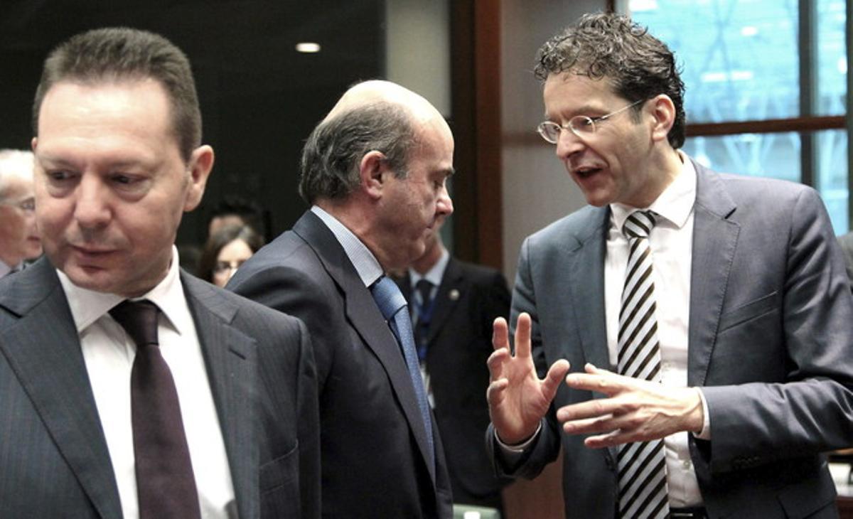 El ministro español de Economía, Luis de Guindos, escucha a su homólogo holandés y presidente del Eurogrupo, Jeroen Dijsselbloem, al inicio del Ecofin, este martes en Bruselas.