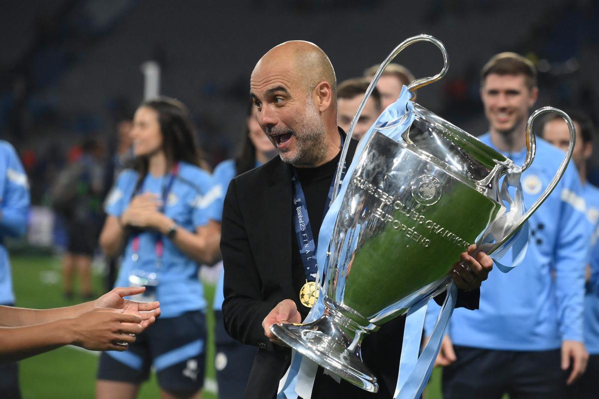 Guardiola sonríe con el trofeo de la Champions en sus manos durante la celebración del City