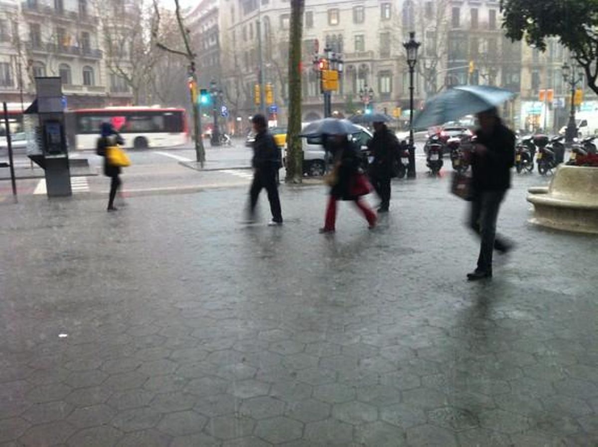 Transeúntes refugiándose de la lluvia en el paseo de Gràcia. Transeúntes refugiándose de la lluvia en el paseo de Gràcia.