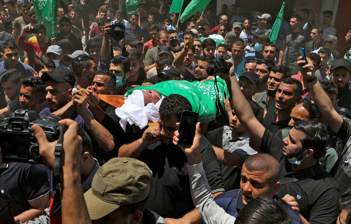 Manifestantes ondean banderas verdes mientras lloran la meurte de varios palestinos por bombardeos israelís en Gaza. 