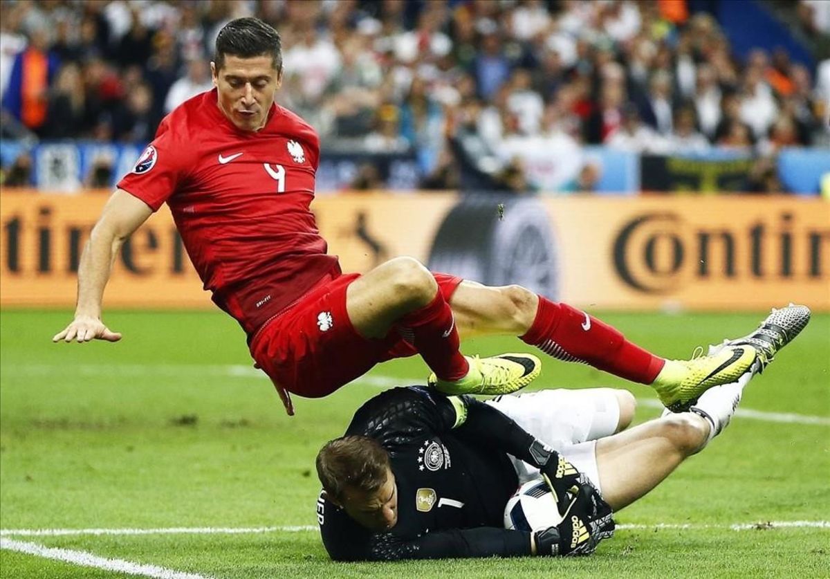 Neuer atrapa el balón ante el delantero polaco Lewandowski. Neuer atrapa el balón ante el delantero polaco Lewandowski.