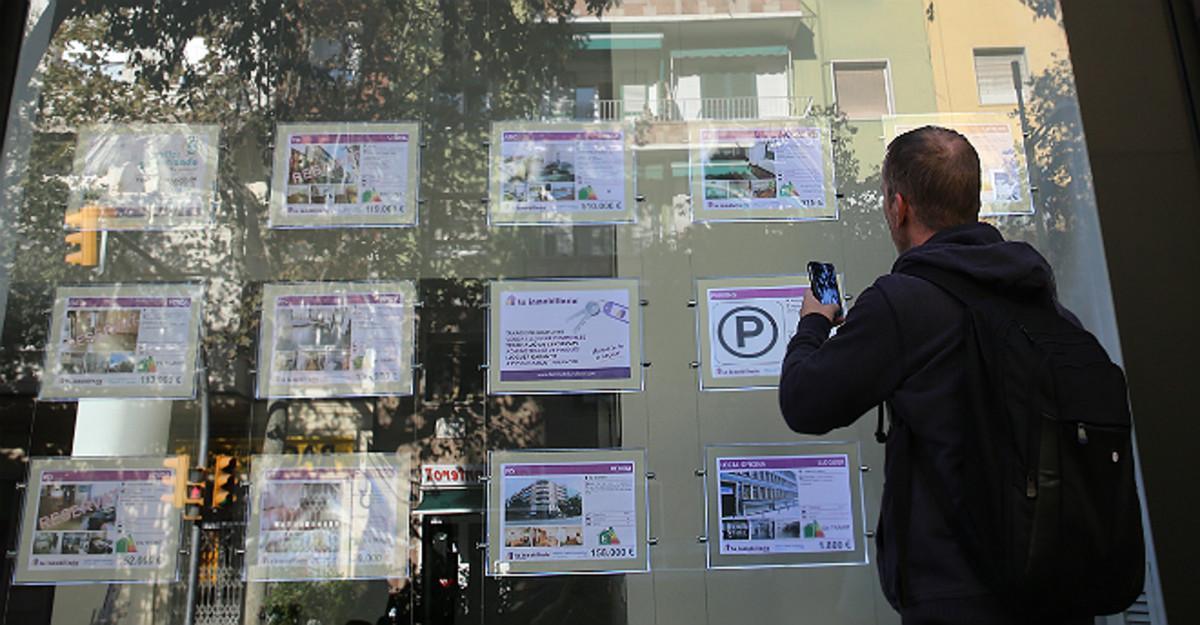 Un hombre consulta los anuncios de una inmobiliaria de Barcelona. 