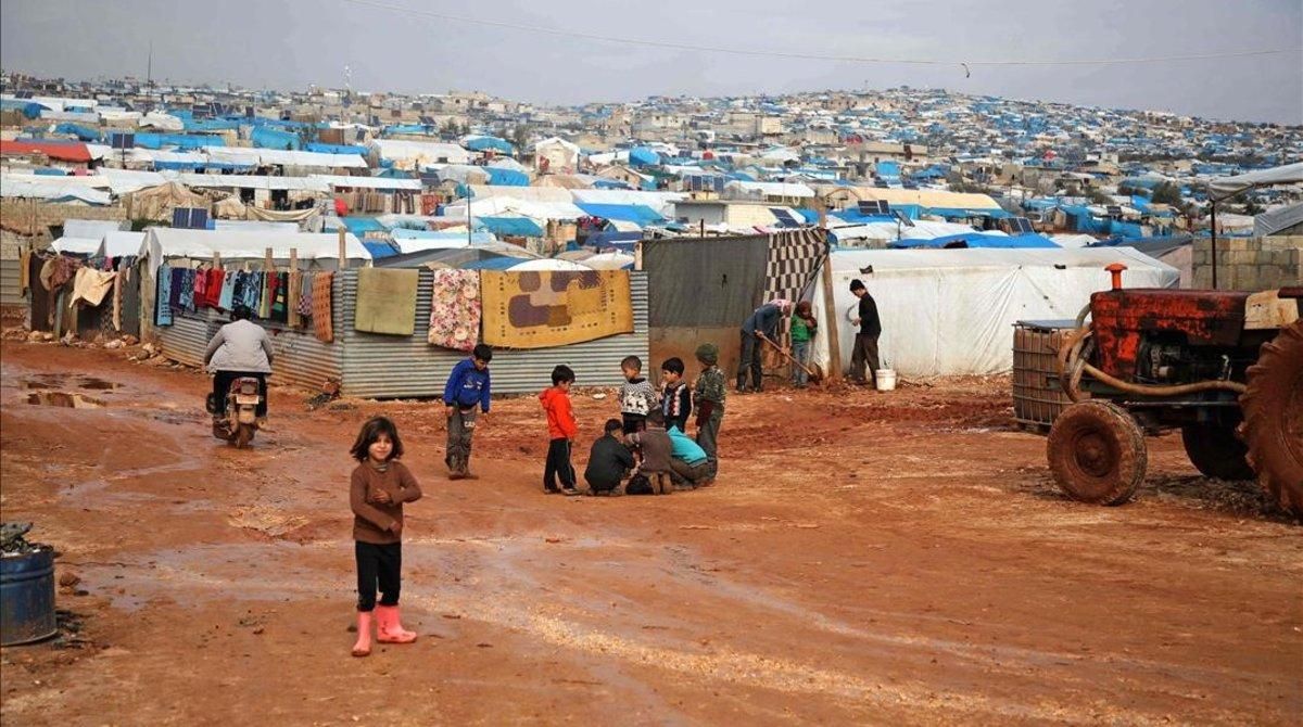 Los niños se reúnen fuera de sus refugios improvisados después de una lluvia torrencial que afectó a un campamento para personas desplazadas cerca de la ciudad de Atme, cerca de la frontera con Turquía, en la provincia de Idlib, al norte de Siria. Los niños se reúnen fuera de sus refugios improvisados después de una lluvia torrencial que afectó a un campamento para personas desplazadas cerca de la ciudad de Atme, cerca de la frontera con Turquía, en la provincia de Idlib, al norte de Siria.