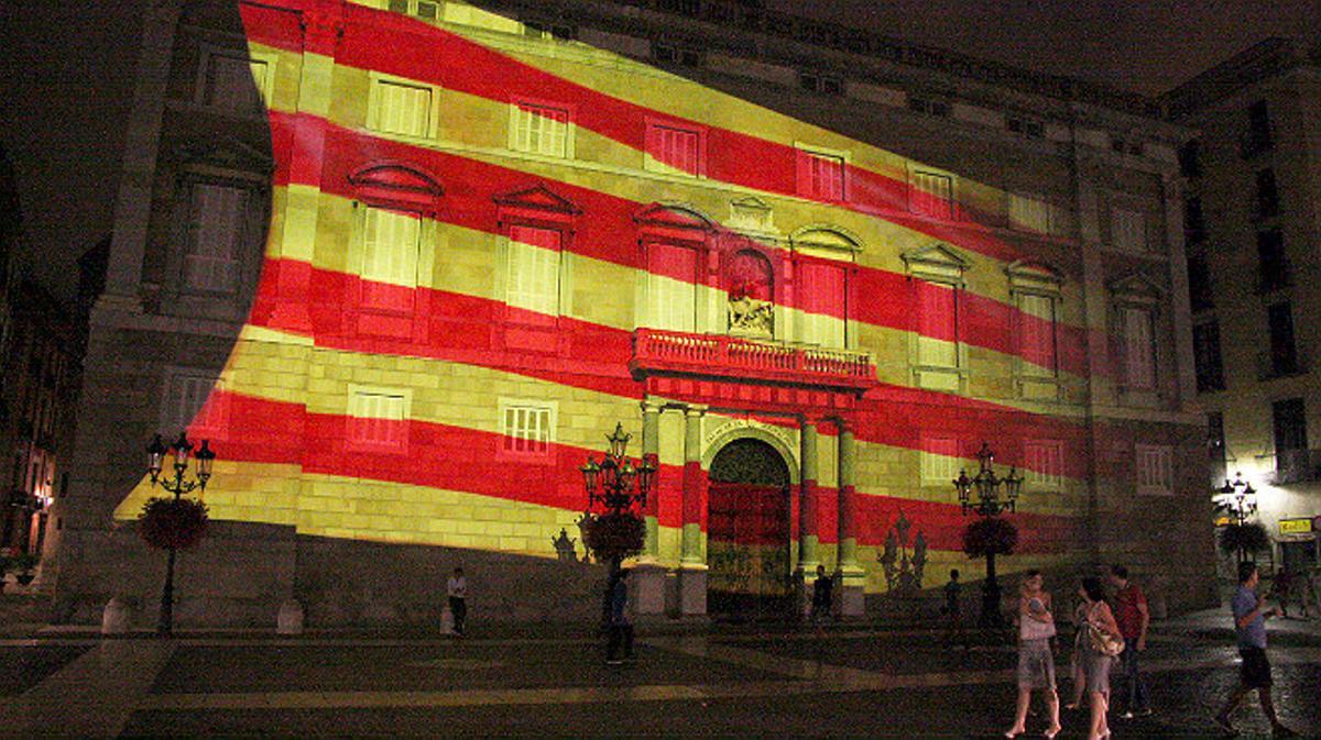 Una gran senyera videoproyectada en la fachada de la Generalitat inaugura los actos de la Diada.