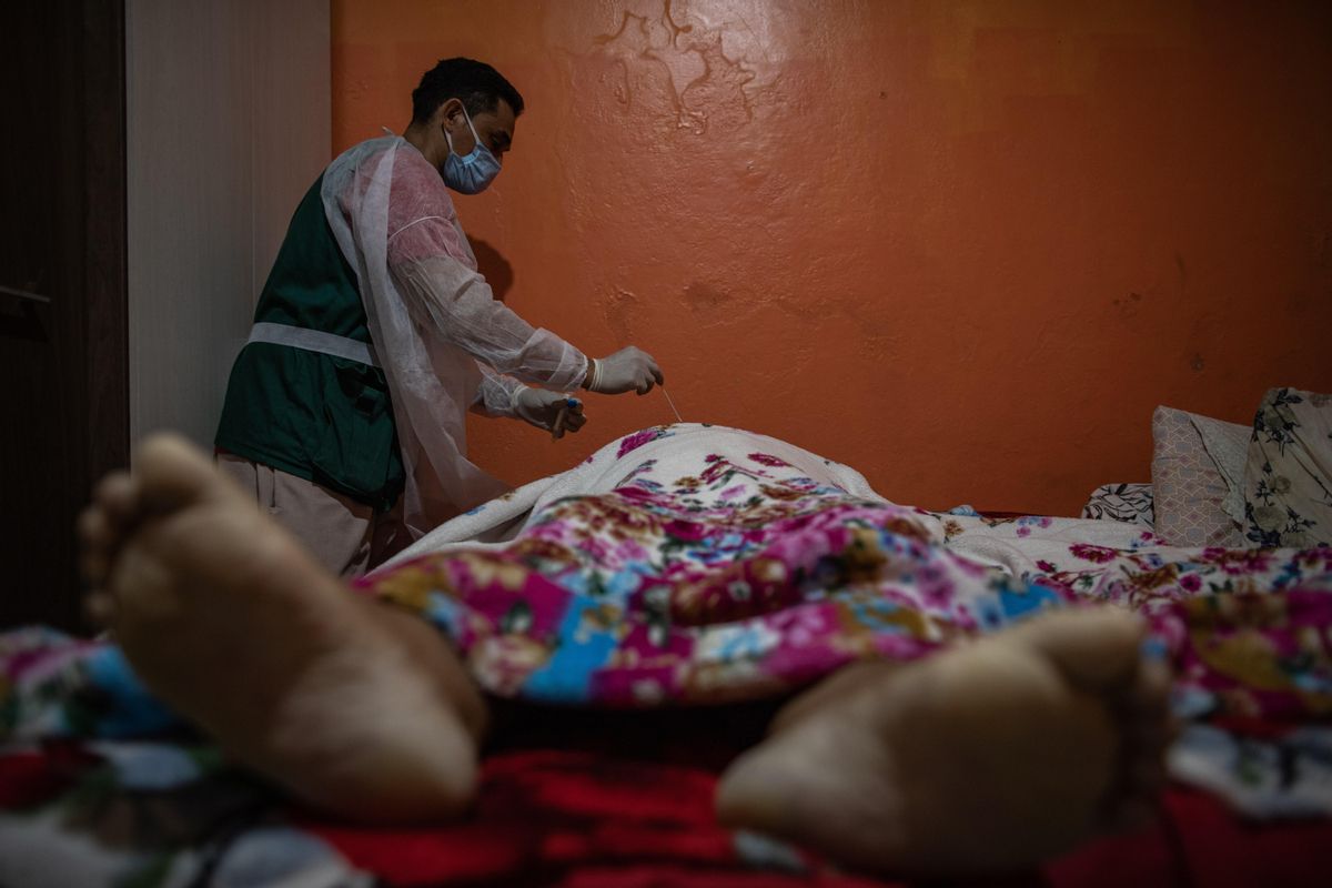 Un profesional del Centro Emisor de Actas de Defunción (CEDO) realiza la prueba del covid-19 a un hombre que falleció en su domicilio en Manaos. Un profesional del Centro Emisor de Actas de Defunción (CEDO) realiza la prueba del covid-19 a un hombre que falleció en su domicilio en Manaos.