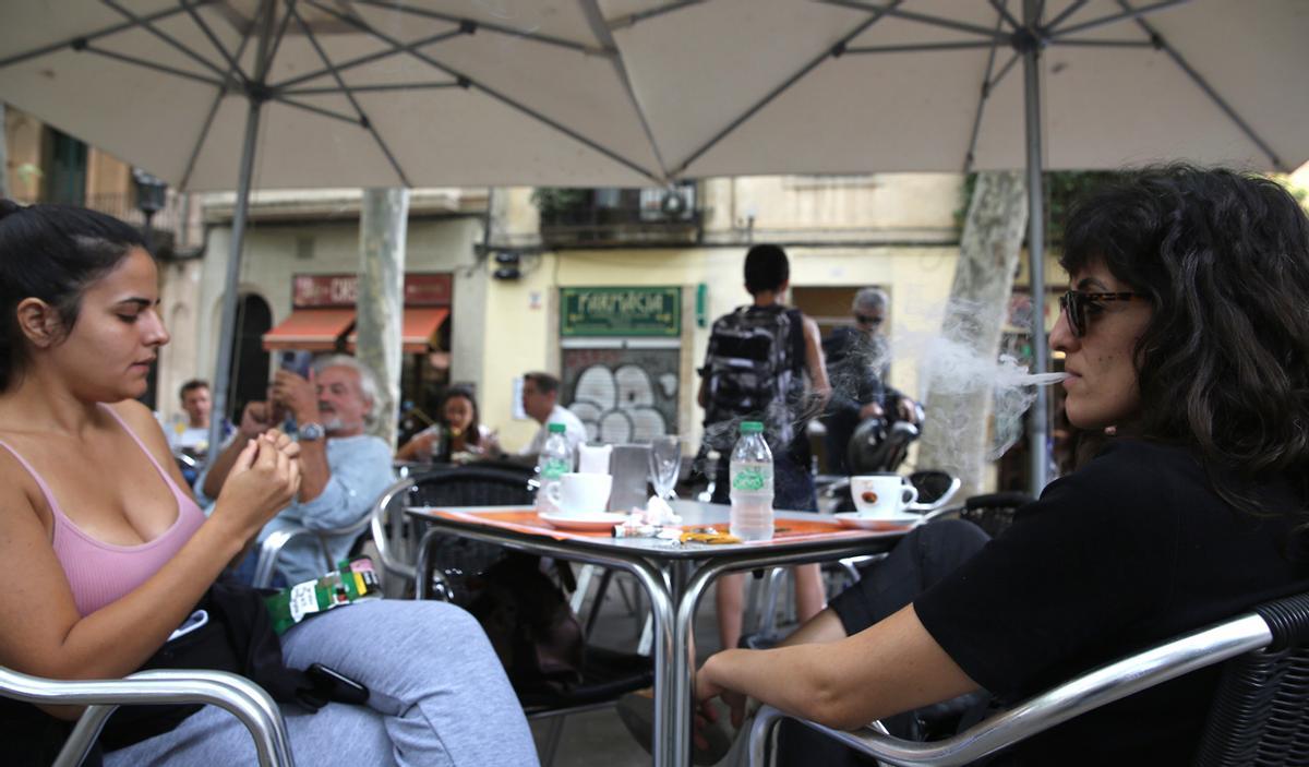 Una chica iraní fuma en una terraza de la plaça Rovira del barrio de Gràcia