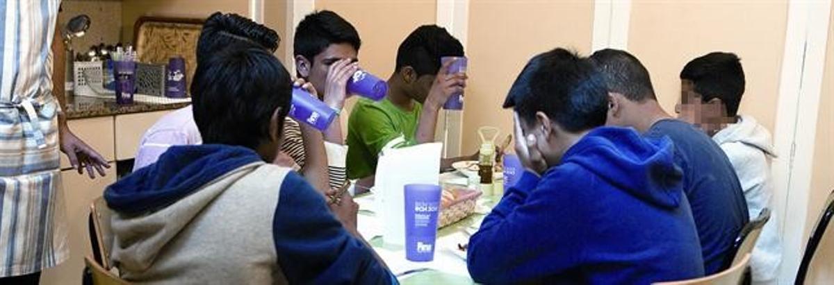Unos chicos comen en la Associació Educativa Integral Raval, ayer.
