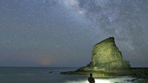 Un turista observa la Vía Láctea desde una playa de la localidad de Tuineje, en la isla de Fuerteventura.