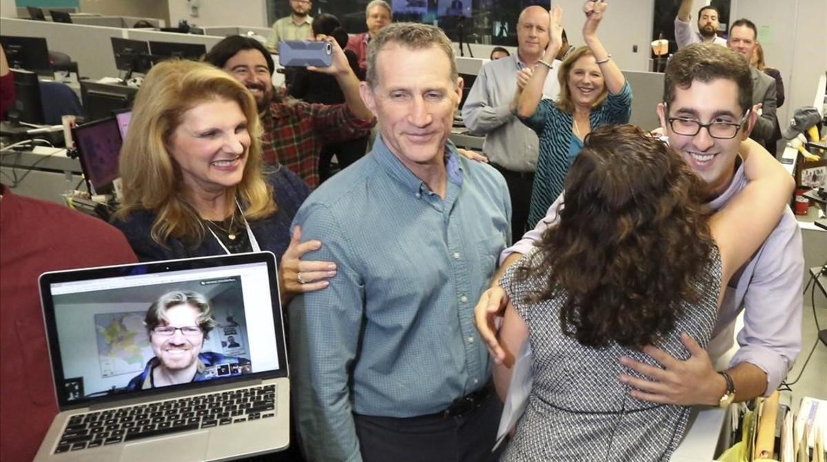 El periodista del ’Miami Herald’ Nicholas Nehamas (derecha) recibe un abrazo de la directora ejecutiva Aminda Marques Gonzalez, mientras Jim Wyss observa vía Skype desde Bogotá, tras escuchar que han recibido el premio Pulitzer por los ’papeles de Panamá’.