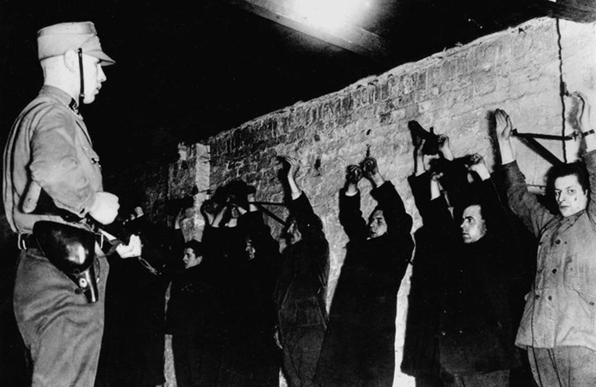 Un guardia SA amenaza a presos políticos recién llegados a los primeros campos de concentración, en 1933. 