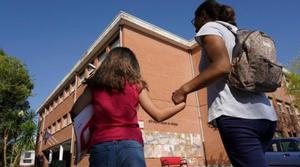 Una madre acompaña a su hija el primer día de colegio, en Madrid, el pasado septiembre.