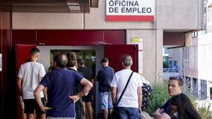 Varias personas esperan para entrar en una oficina de empleo.
