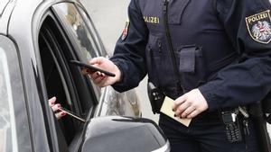 Un policía austriaco comprueba el certificado covid de un ciudadano.