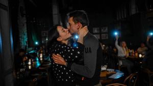Una pareja se besa en un bar de Kiev, mientras los clientes del bar les alumbran con la luz de sus móviles, durante un corte de electricidad en la ciudad.