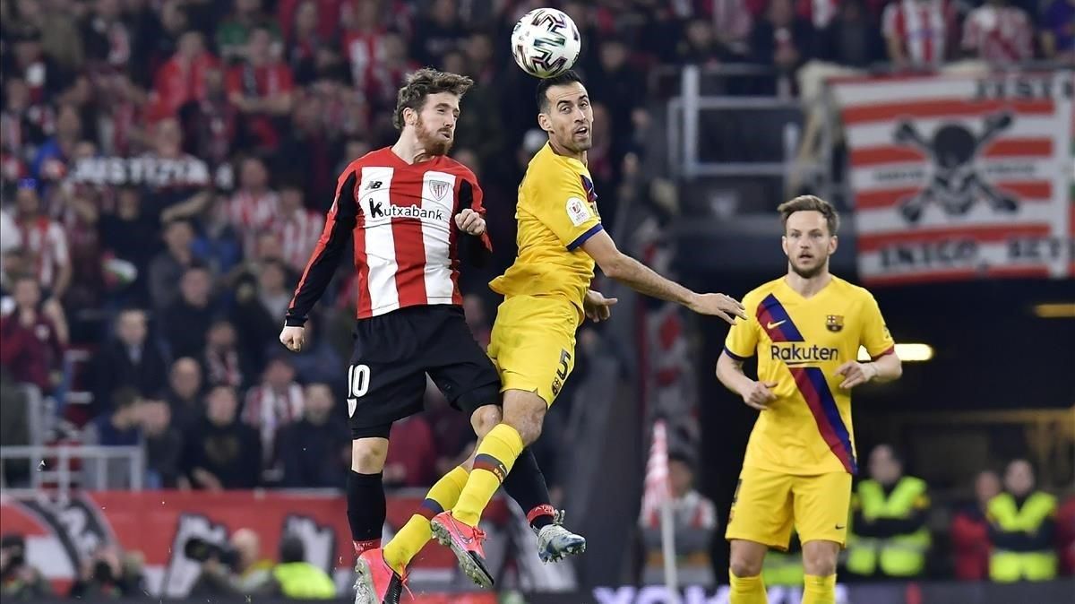 Muniain y Busquets luchan por un balón aéreo ante Rakitic en San Mamés. Muniain y Busquets luchan por un balón aéreo ante Rakitic en San Mamés.