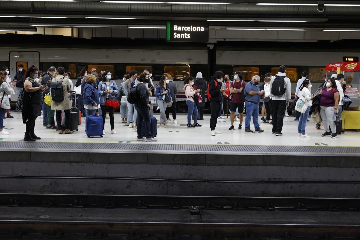 Desconvocada la huelga de maquinistas de Renfe para el puente del Pilar. En la foto, pasajeros esperan su tren en los andenes de la estación de Sants, en Barcelona, el lunes 4 de octubre.
