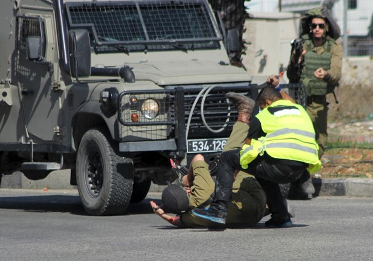 Momento en que un palestino disfrazado de periodista acuchilla a un militar israelí en Hebrón, este viernes. Momento en que un palestino disfrazado de periodista acuchilla a un militar israelí en Hebrón, este viernes.
