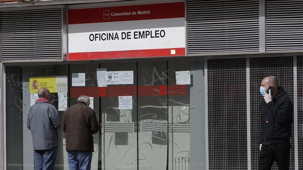 Dos personas leen los carteles de una oficina de empleo cerrada, el pasado lunes. Dos personas leen los carteles de una oficina de empleo cerrada, el pasado lunes.