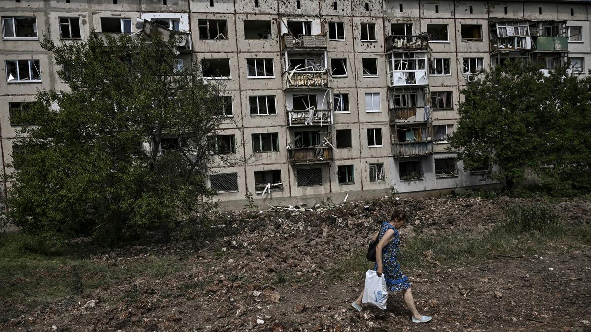 Una mujer pasa junto a un edificio residencial dañado tras combates y bombardeos cerca de Severodonetsk.